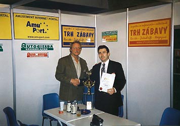 Vydavatel měsíčníku TRH ZÁBAVY Pavel Janoušek blahopřeje Yliyovi Massarskimu z firmy FANTASY ENTERTAINMENT (USA) k získání poháru za výrobek PORTRAIT STUDIO.